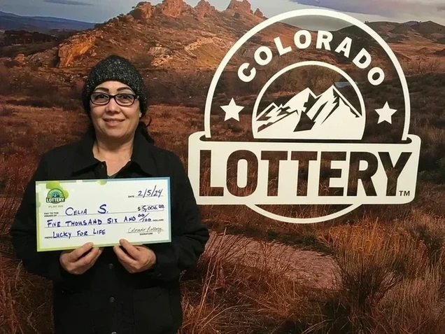 Celia S. 手持一张大型支票，金额为
$5,000，背景为科罗拉多彩票的标志